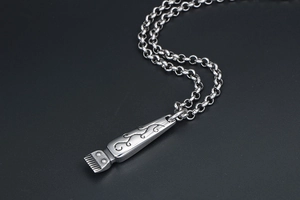 Detailed view of vintage barber clipper pendant with intricate floral engravings