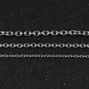 Polished stainless steel cable chains in three widths on a black textured surface