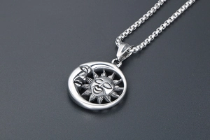 Vue détaillée du pendentif soleil lune rétro avec finition oxydée sur chaîne box