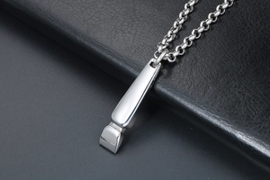 Macro shot of silver titanium hair clipper pendant on textured black leather surface