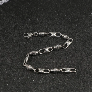 Minimalist stainless steel bracelet featuring cylinder beads and lobster clasp on black background