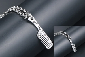 Detailed close-up of a silver comb pendant necklace with ornate engraved cloud patterns