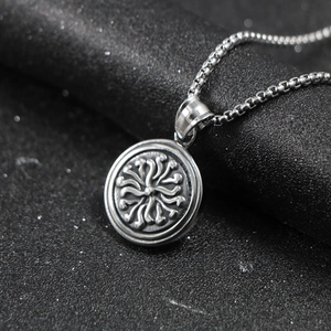 Polished stainless steel round pendant with radial embossed texture on a silver box chain
