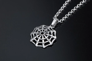 Close-up of punk style spider web pendant with rolo chain in polished stainless steel
