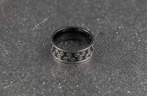 Detail of black and silver triskelion celtic patterns on creative stainless steel band
