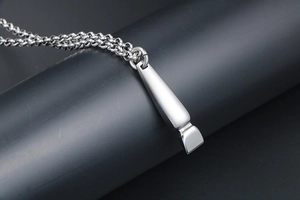 Detailed close-up of a vintage barber clipper pendant in polished stainless steel