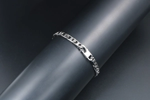 Gros plan sur le bracelet à maillons géométriques en H argenté avec fermoir mousqueton
