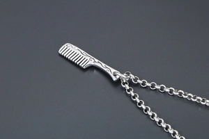 Macro shot of vintage silver comb pendant necklace with detailed scroll engraving
