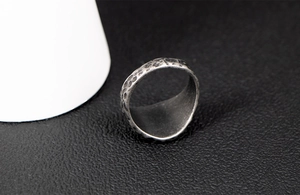 Detail of vintage stainless steel ring with hammered texture and distressed silver finish