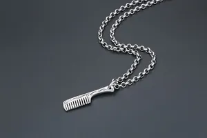Macro detail of silver comb pendant with vintage cloud engraving and thick loop chain