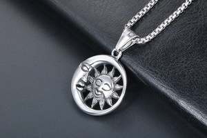 Vue macro du pendentif soleil et lune argenté avec détails de la chaîne à mailles