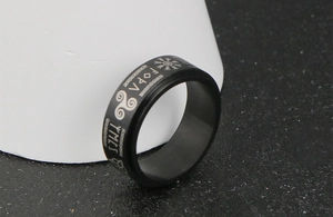 Macro detail of Nordic Viking runes and symbols on black stainless steel spinner ring
