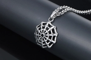 Detailed view of punk spider web pendant in silver titanium steel with thick chain