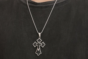 Gros plan d'un pendentif croix en acier titane double couche sur une chaîne boîte