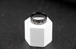 Detailed macro view of stainless steel ring with celtic spiral patterns and black finish