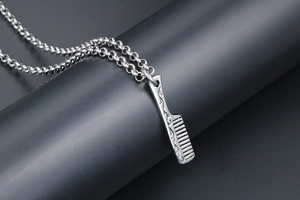 Macro detail of vintage silver comb pendant necklace with retro pattern engraving
