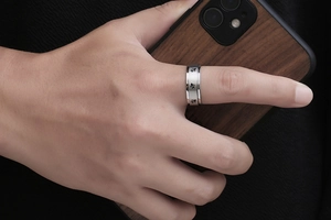 Detail of silver stainless steel spinner ring featuring engraved sea turtle patterns on hand