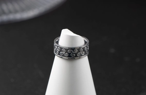Macro shot of vintage stainless steel ring with embossed Triskelion knot patterns