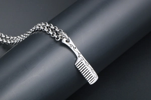 Detailed macro shot of vintage engraved titanium steel comb pendant on a metal display