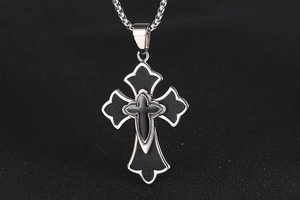 Vue macro du pendentif croix en titane avec incrustation en cuir noir et chaîne carrée
