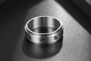 Macro shot of brushed stainless steel ring featuring cute engraved turtle patterns