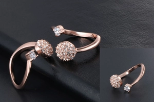 Dettaglio dell'anello a fascia oro rosa con sfere di cristalli pavé e design regolabile