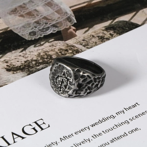 Vintage oxidized stainless steel ring with embossed cross shield and hammered texture