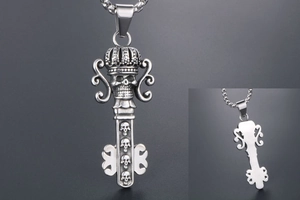 Detailed view of punk style skull key pendant with crown detail and stainless steel chain