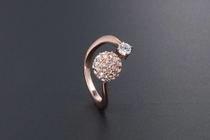 Dettaglio di un anello bypass in oro rosa con una sfera pavé scintillante e diamante solitario