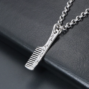 Polished silver stainless steel comb pendant necklace with engraved handle on black leather