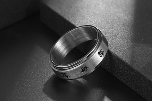 Macro shot of stainless steel spinner ring with brushed silver finish and turtle icons