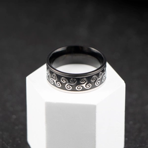 Nordic minimalist black stainless steel ring with silver spiral pattern on white pedestal