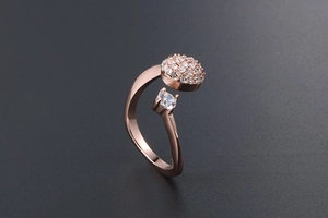 Dettaglio anello in oro rosa con grappolo di zirconi e design asimmetrico regolabile