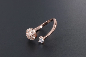 Dettaglio anello oro rosa con micro-pavé di zirconi e fascia aperta asimmetrica