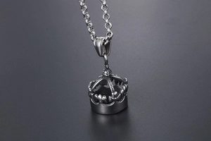 Vue macro d'un pendentif couronne rétro en acier inoxydable aux détails sculptés 3D