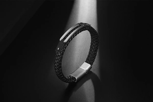 Detail of woven black leather strap with brushed silver magnetic metal clasp for men