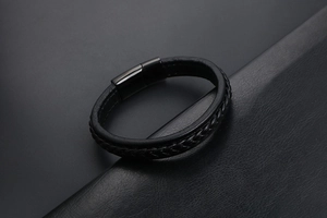 Détail d'un bracelet en cuir tressé noir pour homme avec fermoir magnétique poli