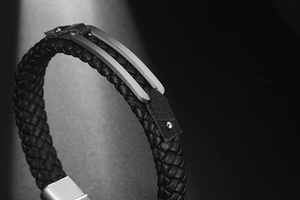 Detail of woven black leather strap and brushed stainless steel magnetic buckle