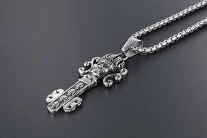 Macro detail of retro gothic skull crown key pendant in vintage silver finish