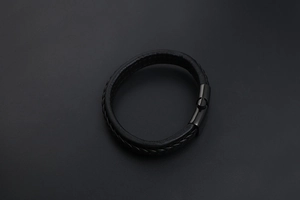 Gros plan d'un bracelet en cuir tressé noir pour homme avec un fermoir magnétique élégant