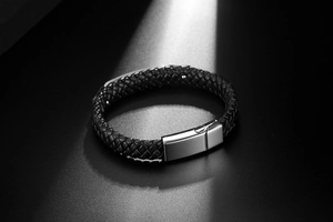 Close-up of black braided leather men's bracelet with a polished silver magnetic clasp