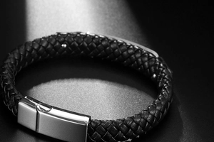 Macro view of braided black leather texture and polished metal buckle for men