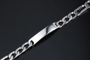 Close-up of a polished titanium steel Figaro chain bracelet with a sleek silver ID plate