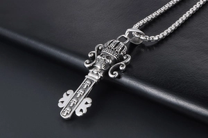 Macro shot of gothic crown skull key pendant in retro stainless steel on black leather
