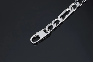 Macro shot of polished titanium steel Figaro chain bracelet with secure lobster clasp