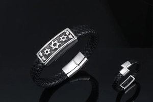Macro shot of men's leather braided bracelet with Star of David engraved metal charm