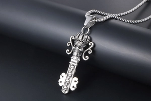 Detailed close-up of retro gothic skull crown key pendant in oxidized stainless steel