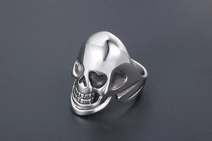 Macro detail of vintage punk skull ring in polished stainless steel with rustic shadows