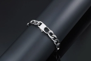 Polished silver titanium cuban link bracelet with rectangular clasp on display