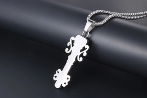 Detailed macro view of polished silver skull crown pendant on a square link chain